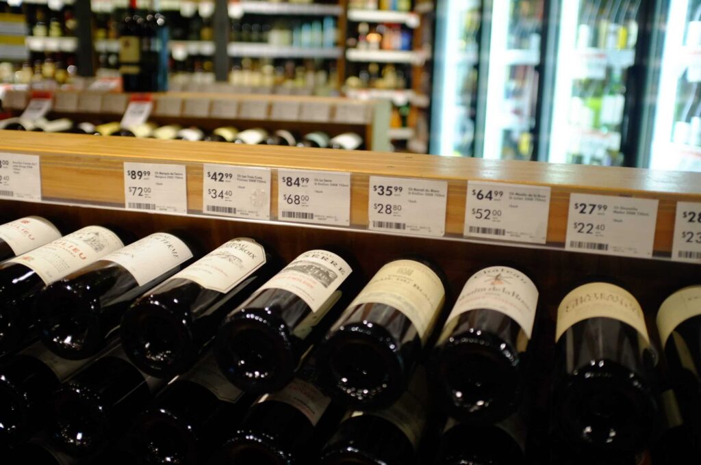 Precificação - estante de vinhos com os respectivos acima